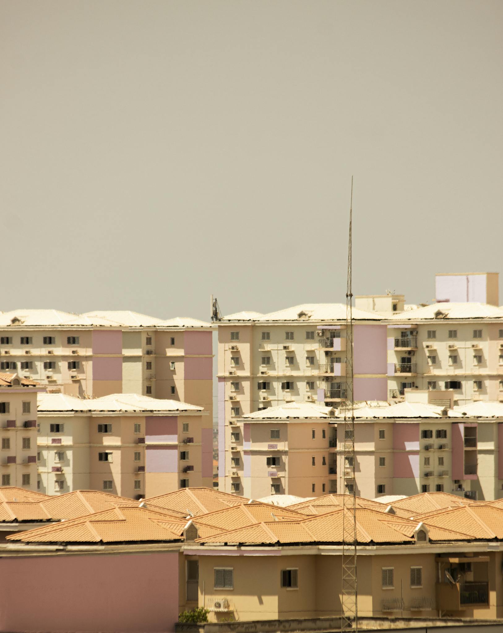 A view of modern pastel-colored residential buildings in an urban setting under clear skies.