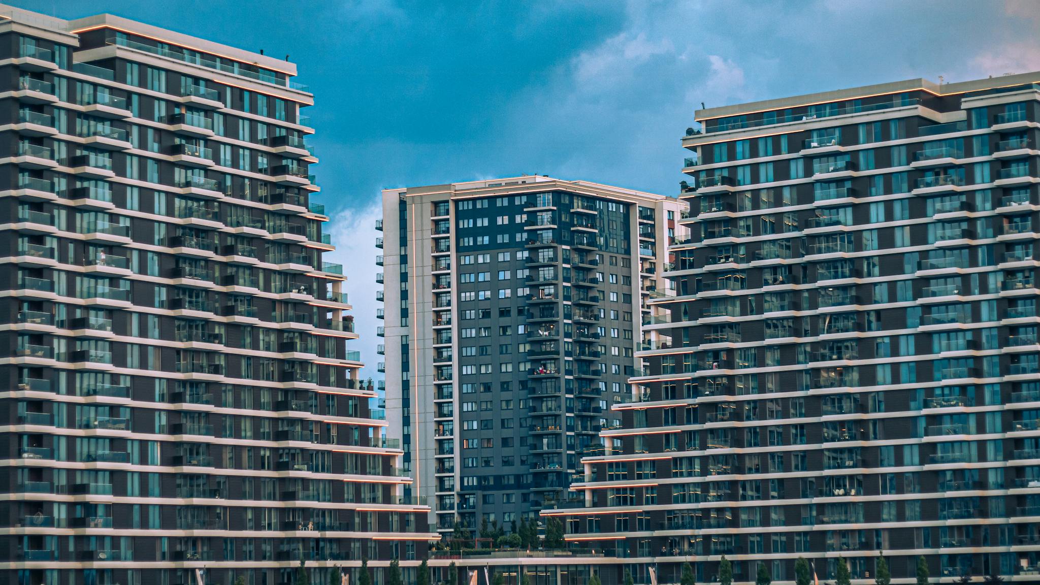Contemporary high-rise apartments showcasing modern architecture against a blue sky.